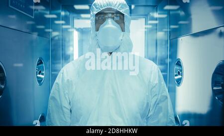 Scienziato Virologo Factory Worker in tuta tuta si disinfetta in camera doccia decontaminazione. Risposta di emergenza a rischio biologico. High Tech Foto Stock