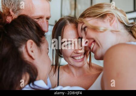 Primo piano di amici sorridenti in piedi in un cerchio indoor. Foto Stock