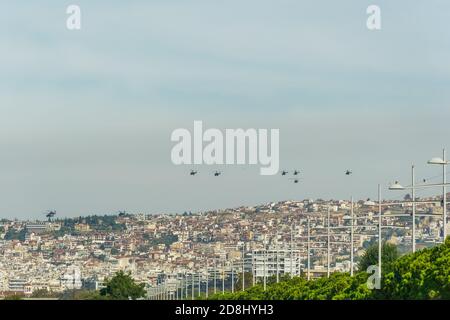 Elicotteri militari che volano sopra una città. Greek Air Force AH-64 Apache, Kiowa Warrior & Huey UH-1H sulla formazione a Salonicco il 28 ottobre commemorando il no ellenico contro il 1940 ultimatum italiano. Foto Stock