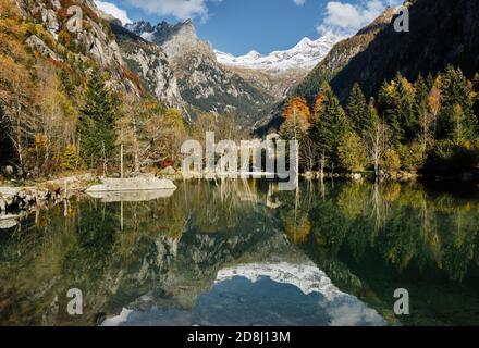 Vista panoramica sul laghetto con riflessi e boschi multicolori, in stagione autunnale lago in Val di Mello, Val Masino, Italia - lombardia Foto Stock
