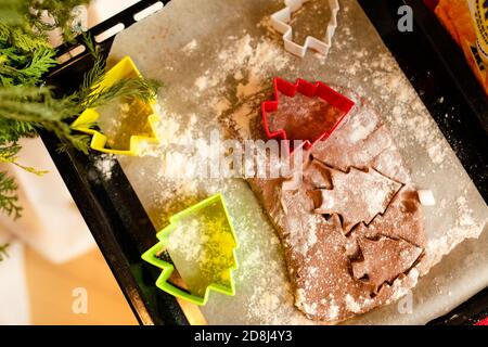 Colpo dettagliato di biscotti di pan di zenzero pasta e taglierina di biscotti di plastica su piano di lavoro in legno Foto Stock