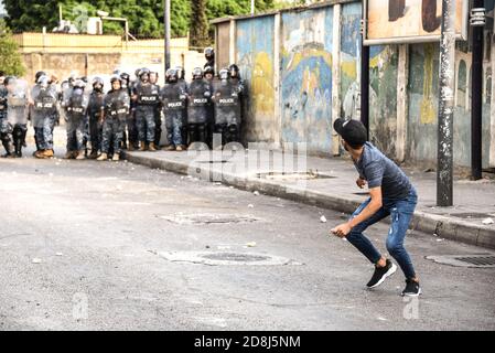 Beirut, Libano, 30 ottobre 2020. Gettare pietre alla polizia come un piccolo gruppo di uomini di Tripoli e Beirut scontro con le forze libanesi di sicurezza interna. Scuffi sono scoppiati durante un tentativo del gruppo panislamico Hizb Ut Tahrir di marciare all'ambasciata francese per protestare contro ciò che essi hanno visto come la posizione anti-islamica del presidente Emmanuel Macron. Le emozioni hanno corso alto come è stato sentito il profeta Maometto è stato disrispettato durante il suo mese di compleanno. Credit: Elizabeth Fitt/Alamy Live News Foto Stock