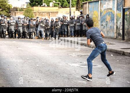 Beirut, Libano, 30 ottobre 2020. Gettare pietre alla polizia come un piccolo gruppo di uomini di Tripoli e Beirut scontro con le forze libanesi di sicurezza interna. Scuffi sono scoppiati durante un tentativo del gruppo panislamico Hizb Ut Tahrir di marciare all'ambasciata francese per protestare contro ciò che essi hanno visto come la posizione anti-islamica del presidente Emmanuel Macron. Le emozioni hanno corso alto come è stato sentito il profeta Maometto è stato disrispettato durante il suo mese di compleanno. Credit: Elizabeth Fitt/Alamy Live News Foto Stock