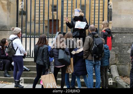 Oxford, Oxfordshire, Regno Unito - Venerdì 30 Ottobre 2020 - i visitatori del centro di Oxford ascoltano una guida turistica fuori dalla Bodleian Library mentre Oxford si prepara ad entrare nelle restrizioni del Covid Tier 2 domani sabato 31 Ottobre. Photo Steven May / Alamy Live News Foto Stock