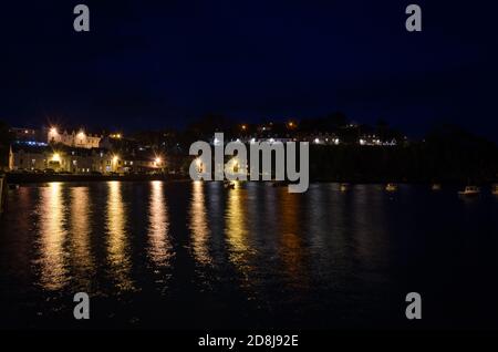 Paesaggio della città, di Portree di notte con le luci del lampione riflesse sulle acque del mare, Isola di Skye, Regno Unito Foto Stock