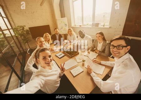 Foto degli uomini d'affari otto colleghi della gara d'età della diversità siedono tabella condividere anti crisi crash idee team professionisti facendo selfie costruzione di squadra Foto Stock