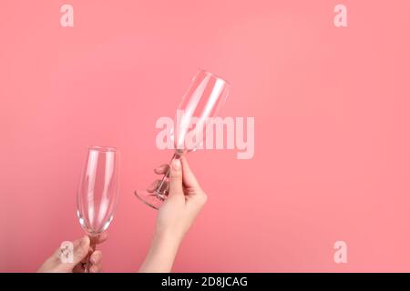 Bicchieri da vino su sfondo rosa nelle mani di una donna. Foto Stock