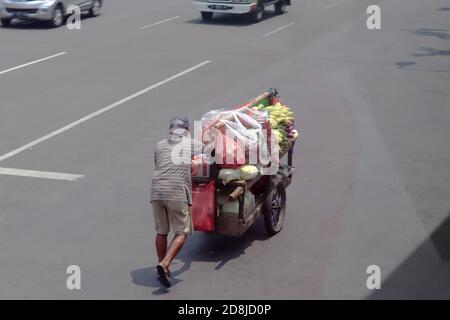 giacarta / Indonesia - 23 settembre 2020. Un commerciante mobile di verdure che spinge il suo carrello durante il giorno Foto Stock