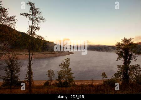 Un lago di montagna panoramico nel cuore delle montagne Appalachiane. L'immagine è stata presa all'alba quando una nebbia spessa era scesa sopra il lago generando una spe Foto Stock