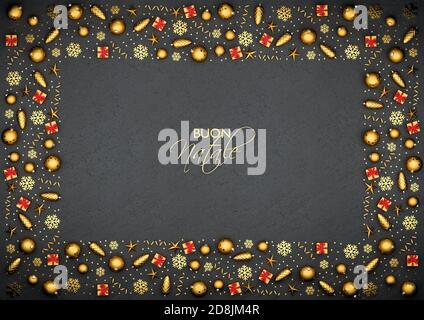Piatto Lay ornamenti dorati di natale disposti come una cornice su una piastra di pietra nera. Testo italiano 'buon Natale' (buon Natale) nel mezzo. Foto Stock