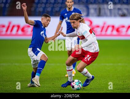 Gelsenkirchen, Germania. 30 Ott 2020. Calcio: Bundesliga, FC Schalke 04 - VfB Stuttgart, 6° incontro nella Veltins Arena. Borna Sosa di Stoccarda (a destra) e l'ammina di Schalke Harit combattono per la palla. Credito: Guido Kirchner/dpa - NOTA IMPORTANTE: In conformità con le norme del DFL Deutsche Fußball Liga e del DFB Deutscher Fußball-Bund, è vietato sfruttare o sfruttare nello stadio e/o nel gioco le fotografie scattate sotto forma di sequenze di immagini e/o serie di foto di tipo video./dpa/Alamy Live News Foto Stock