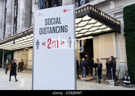 I cartelli di distanza sociale di due metri consigliano agli acquirenti di Oxford Street di stare lontani da Selfridges, secondo le linee guida del governo durante la seconda ondata della pandemia britannica di Coronavirus, il 30 ottobre 2020, a Londra, Inghilterra. Foto Stock