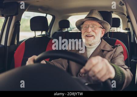 Primo piano ritratto della sua bella esperienza allegra allegria felice uomo dai capelli grigi che guida l'auto in ingorgo che tiene il volante godendo lontano Foto Stock