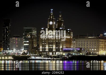 Vista generale notturna del lungomare di Liverpool e di Liver Edificio preso dal lato Wirral del fiume Foto Stock