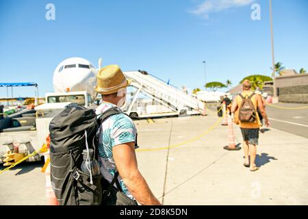 Un giovane uomo in viaggio arriva in aereo con passaporto sulla striscia di atterraggio Foto Stock