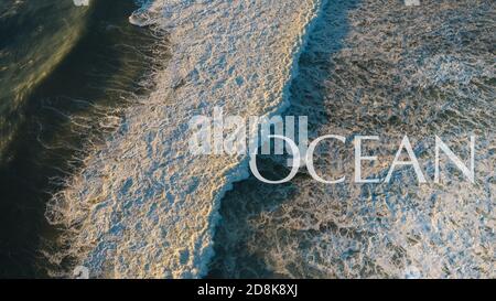 Vista dall'alto dell'oceano con onde che si infrangono e molta schiuma bianca. Oceano potente Foto Stock