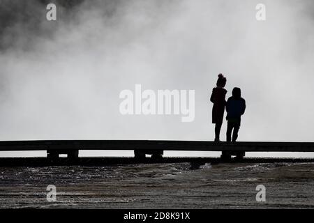 Yellowstone National Park turisti famiglie bambini silhouette sulla passerella sopra gruppi di geyser Foto Stock