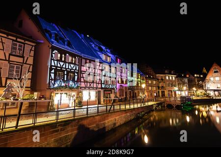 Tradizionale stile alsaziano semi-case con travi di legno e il fiume Lauch nella Petite Venise o piccola Venezia, la città vecchia di Colmar, decorata e illuminata di christma Foto Stock