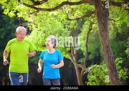 Asian Senior coppia jogging nel parco naturale Foto Stock