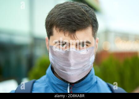 Giovane uomo in maschera medica da covid-19 pandemia all'aperto. Foto Stock