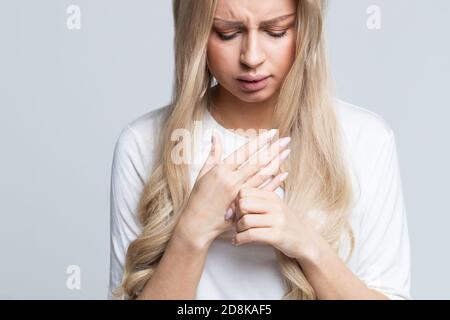 Donna con dolore alle mani o alle dita, esercizi di stretching e massaggio per le dita dopo il lavoro. Artrite, sindrome del concetto di lavoro d'ufficio Foto Stock