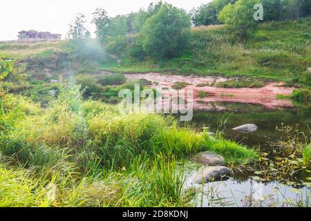 La costa di un piccolo fiume, grandi pietre. Foto Stock
