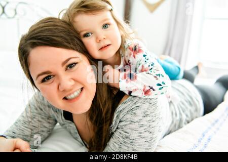 Una madre e figlia godere nel letto di casa Foto Stock