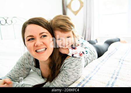 Una madre e figlia godere nel letto di casa Foto Stock