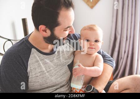 Un bel padre con bambino a letto Foto Stock