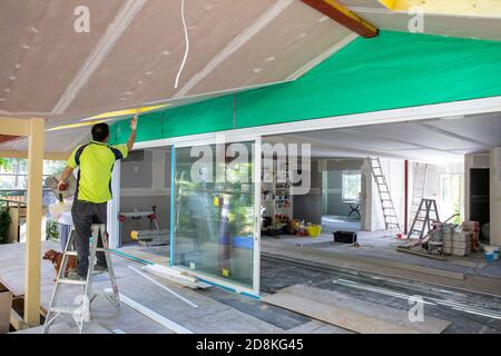 Tradesman installazione di cartongesso in una casa di Sydney in fase di modernizzazione, Sydney, Australia Foto Stock