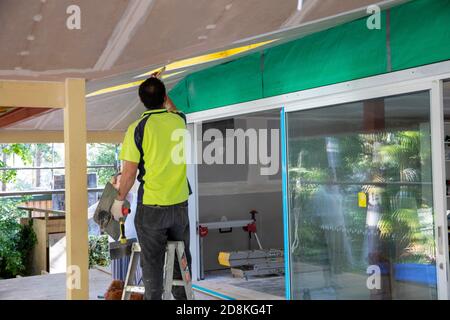 Lavori di ristrutturazione e ampliamento della casa di Sydney come commerciante che completa l'installazione di cartongesso, Sydney, NSW, Australia Foto Stock