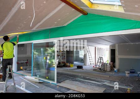 Lavori di ristrutturazione e ampliamento della casa di Sydney come commerciante che completa l'installazione di cartongesso, Sydney, NSW, Australia Foto Stock