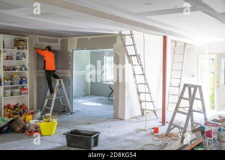 Lavori di ristrutturazione e ampliamento della casa di Sydney come commerciante che completa l'installazione di cartongesso, Sydney, NSW, Australia Foto Stock