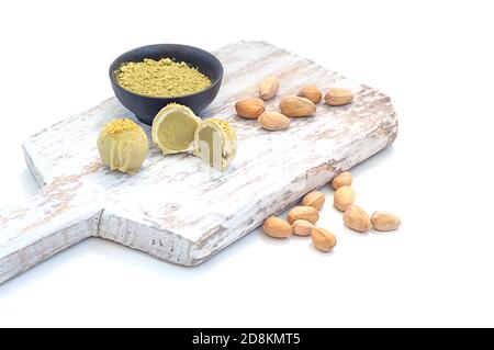 Pistacchio matcha caramella bianca al cioccolato su tavola di legno, su fondo bianco. Spazio di copia Foto Stock