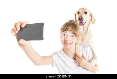 Bella donna teen e il suo bel cane Golden Retriever sopra sfondo bianco che fa selfie Foto Stock