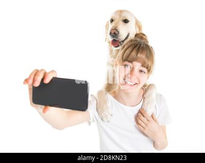 Bella donna teen e il suo bel cane Golden Retriever sopra sfondo bianco che fa selfie Foto Stock