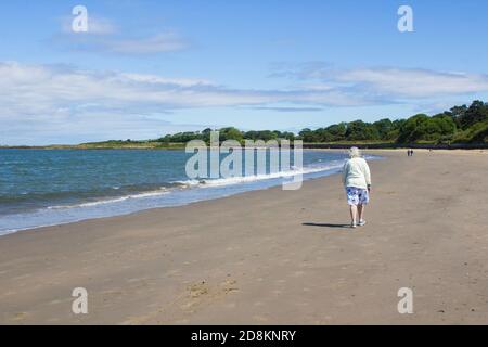 6 giugno 2020 una donna anziana e altri camminano spiaggia per l'esercizio durante la pandemia di Corona Virus a Ballyholme A Bangor in Irlanda del Nord su un bre Foto Stock