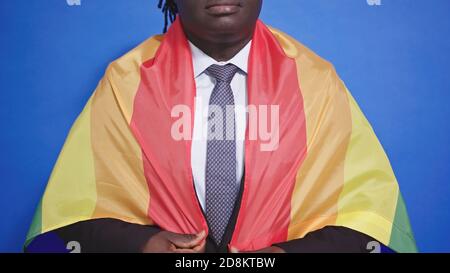 Uomo nero afroamericano irriconoscibile in elegante cravatta con motivo rivestito con bandiera dell'orgoglio arcobaleno. Foto di alta qualità Foto Stock