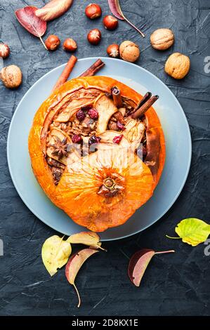 Zucca ripiena di granola e frutta secca. Dessert autunnale popolare. Foto Stock