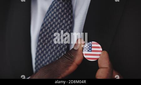 Primo piano, uomo nero afroamericano in abbigliamento formale con stemma usa. . Foto di alta qualità Foto Stock