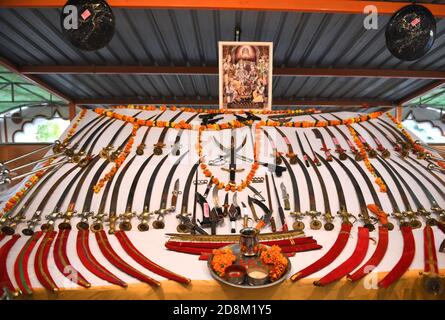 Beawar, Rajasthan, 25 ottobre 2020: Armi poste di fronte alla foto di Lord Rama durante la cerimonia di Shastra Puja (culto delle armi) in occasione di Vijayadashmi Foto Stock