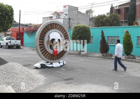 Città del Messico, Messico. 30 Ott 2020. CITTÀ DEL MESSICO, MESSICO - OTTOBRE 30: Una persona indossa la maschera mentre cammina davanti a un monumentale cranio fatto di cartone, sono stati messi per decorare le strade di Tlahuac per celebrare il giorno dei morti ( dia de Muertos) in mezzo a Covid-19 pandemia. Il 30 ottobre 2020 a Città del Messico, Messico. Credit: Ismael Rosas/Eyepix Group/The Photo Access Credit: The Photo Access/Alamy Live News Foto Stock