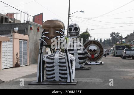 Città del Messico, Messico. 30 Ott 2020. CITTÀ DEL MESSICO, MESSICO - OTTOBRE 30: Una persona indossa la maschera mentre cammina davanti a un monumentale cranio fatto di cartone, sono stati messi per decorare le strade di Tlahuac per celebrare il giorno dei morti ( dia de Muertos) in mezzo a Covid-19 pandemia. Il 30 ottobre 2020 a Città del Messico, Messico. Credit: Ismael Rosas/Eyepix Group/The Photo Access Credit: The Photo Access/Alamy Live News Foto Stock