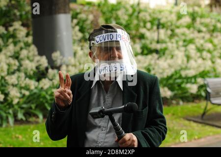 Melbourne, Australia 31 Ott 2020 UN protetore che indossa uno scudo facciale con il messaggio "Covid 1984" scritto su di esso pone e fa un gesto di vittoria nei Treasury Gardens, Melbourne. Credit: Michael Currie/Alamy Live News Foto Stock