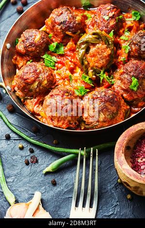 Cotolette o polpette speziate fatte in casa, stufate con fagioli di asparagi. Foto Stock