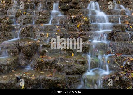 Un closeup di una diga di roccia con acqua che cade sopra esso. Foto Stock