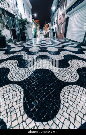 Empty Rua Frederico Arouca, una strada pedonale con molti negozi di souvenir e ristoranti a Cascais, Portogallo Foto Stock