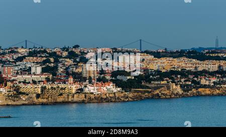 Vista da Cascais verso est verso Lisbona con Ponte 25 de Abril e Rei Cristo Visible, Lisbona, Portogallo Foto Stock