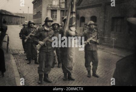 Berlino Est, Repubblica democratica tedesca, 1970. L'ufficiale sovietico guarda un gruppo di soldati della Germania orientale con armi e una bandiera prima di una parata Foto Stock