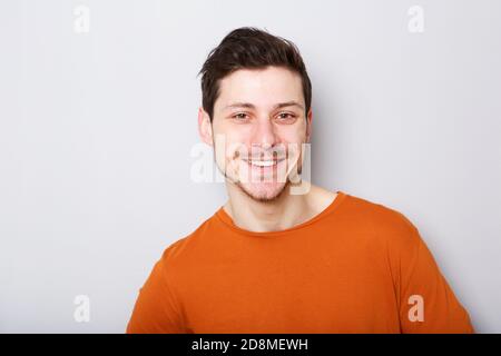 Primo piano ritratto di un giovane sorridente su sfondo grigio Foto Stock